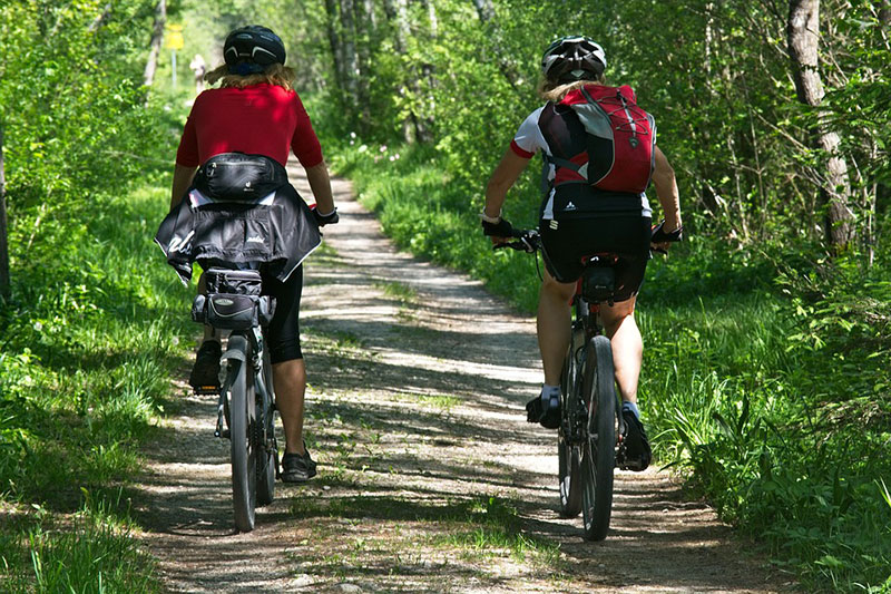 2 women cycling down a lane